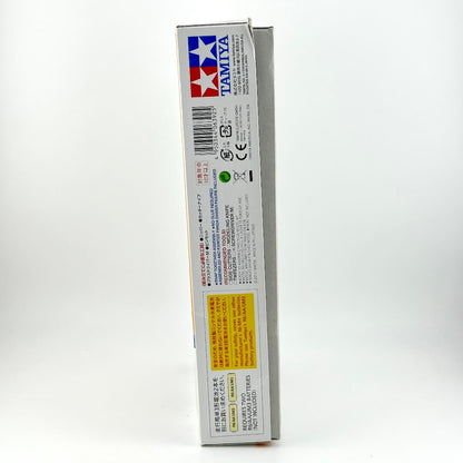 The side panel of a Tamiya model kit box, showing the brand logo, barcode, and various regulatory text and icons.