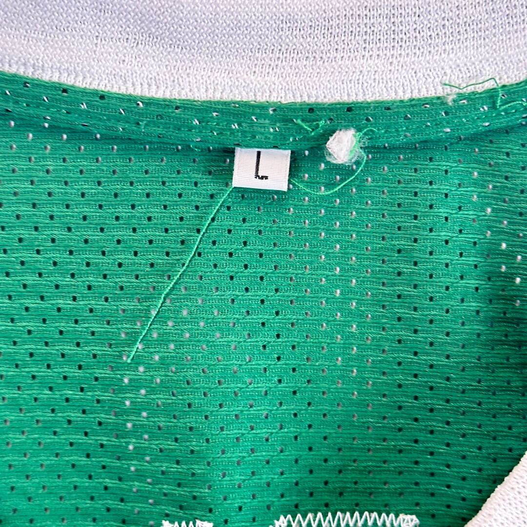 Close-up of size tag at back of neck reading "L". 