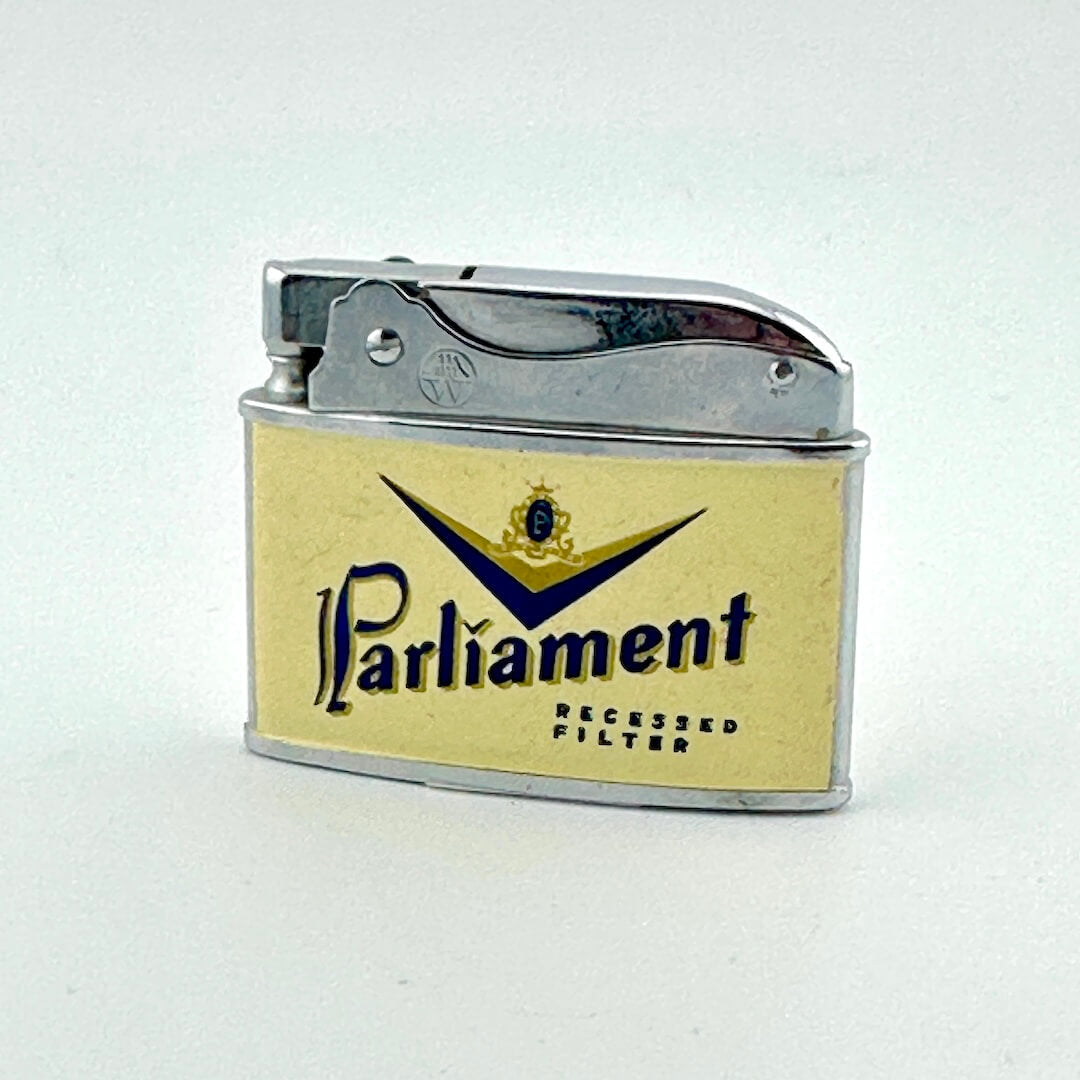 A vintage Parliament lighter with a cream-colored front faceplate, and a polished silver metal body and lid.