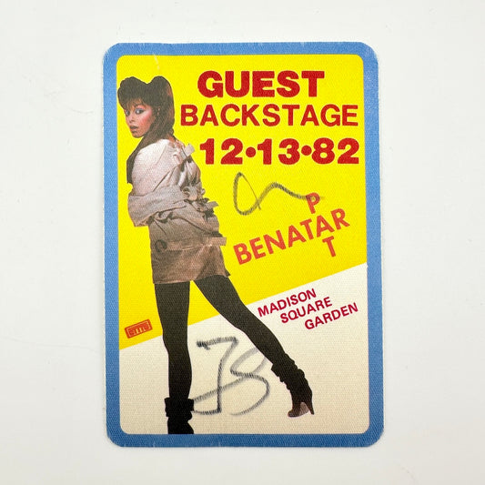 A vintage backstage pass card with a bright yellow background, blue border, and red text. 
