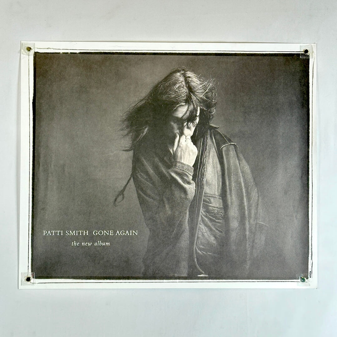 black and white with Patti Smith in leather jacket touching her face with artist and album info to left.