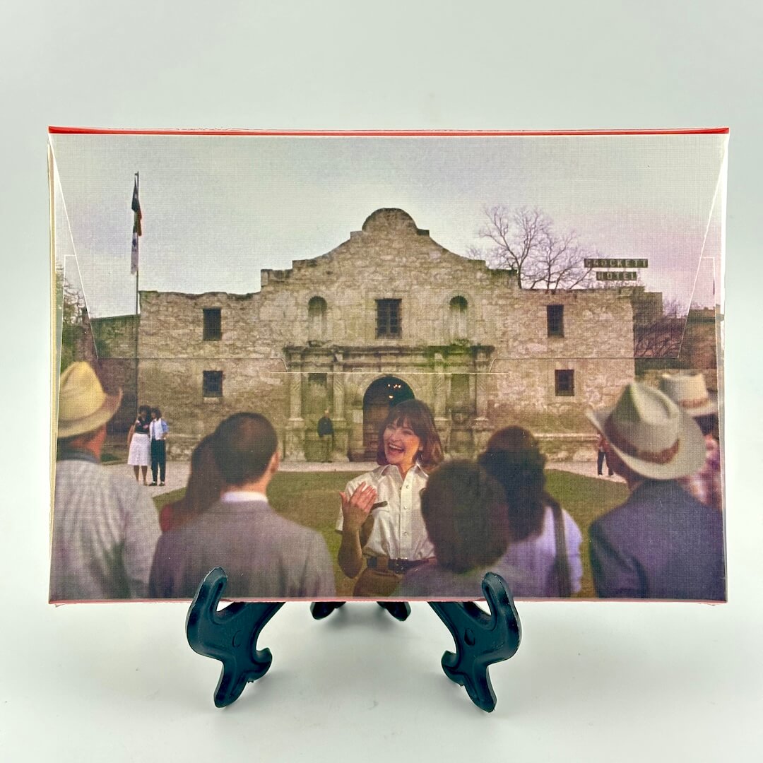 Backside of packaging for postcard set featuring image of the Alamo and tour guide. 