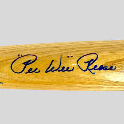 Wooden bat with blue signature on a beige background
