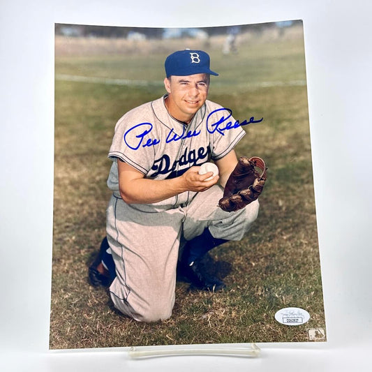 Vintage baseball player in a 'Dodgers' uniform with a glove and ball, on a grassy field.