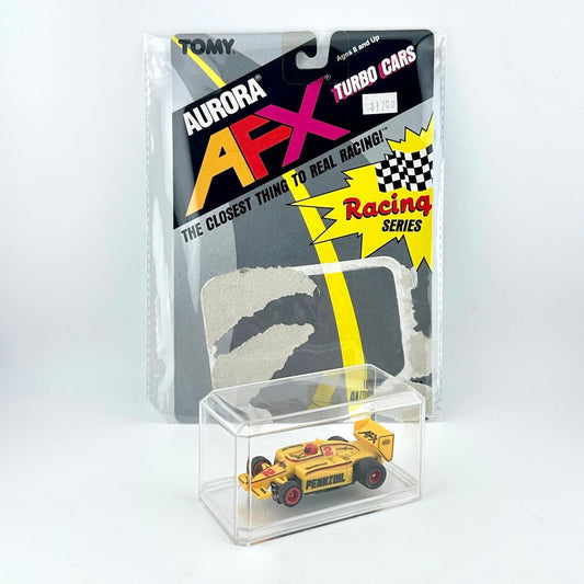 Yellow toy race car in clear display case with Aurora AFX packaging in the background