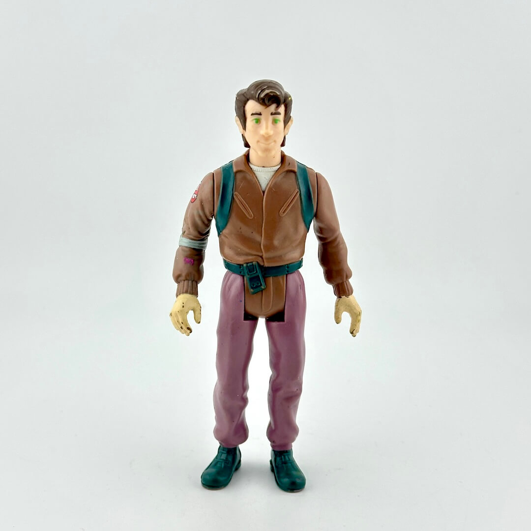 Action figure in a brown jacket and purple pants on a white background