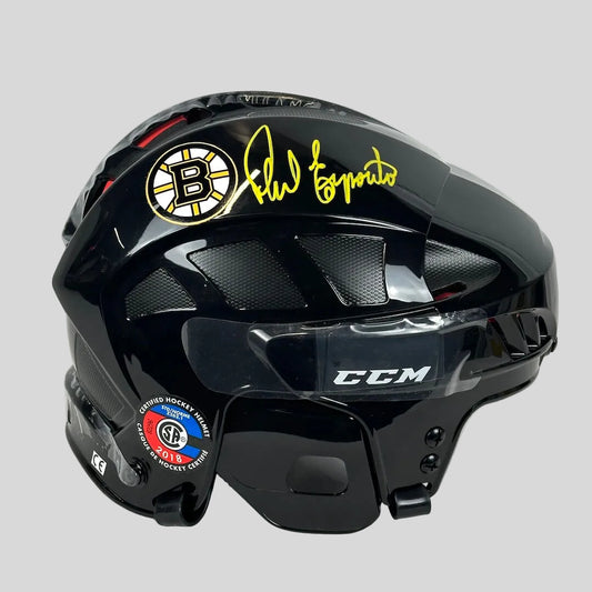 Black hockey helmet with Bruins logo and signature on a white background
