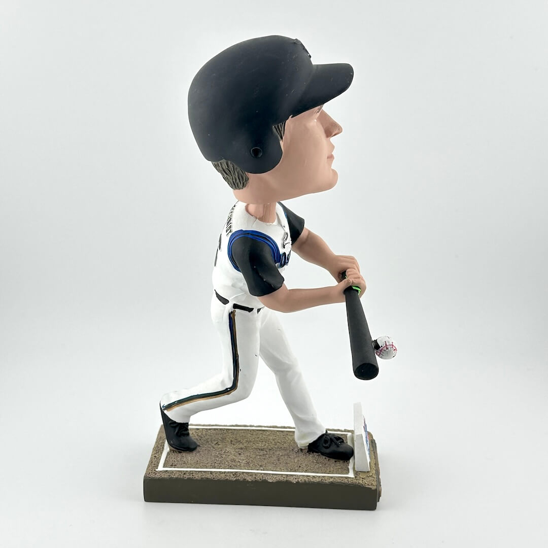 Bobblehead of a baseball player in a white uniform with a black bat on a white background