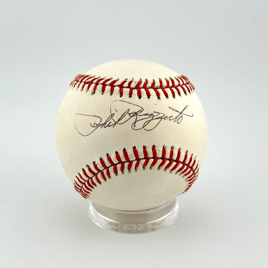 Baseball with red stitching on a clear stand against a white background