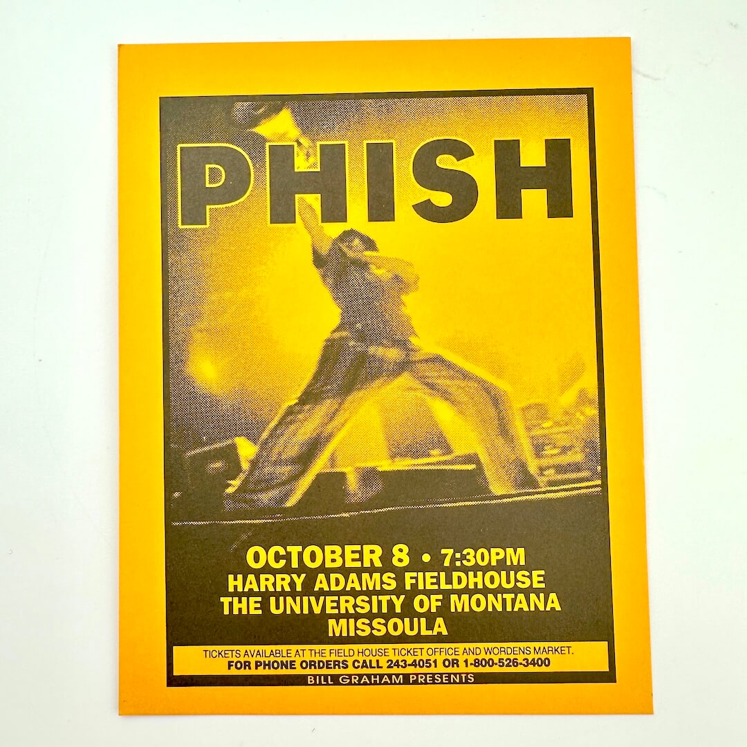 Promotional poster for Phish concert at the University of Montana with a yellow border.