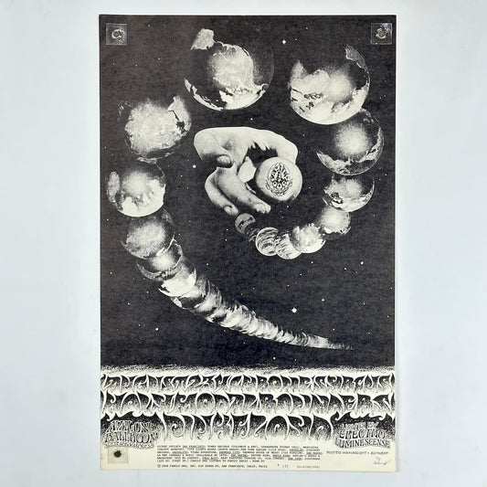 Black and white poster with a hand holding a sphere surrounded by celestial bodies on a light gray background.