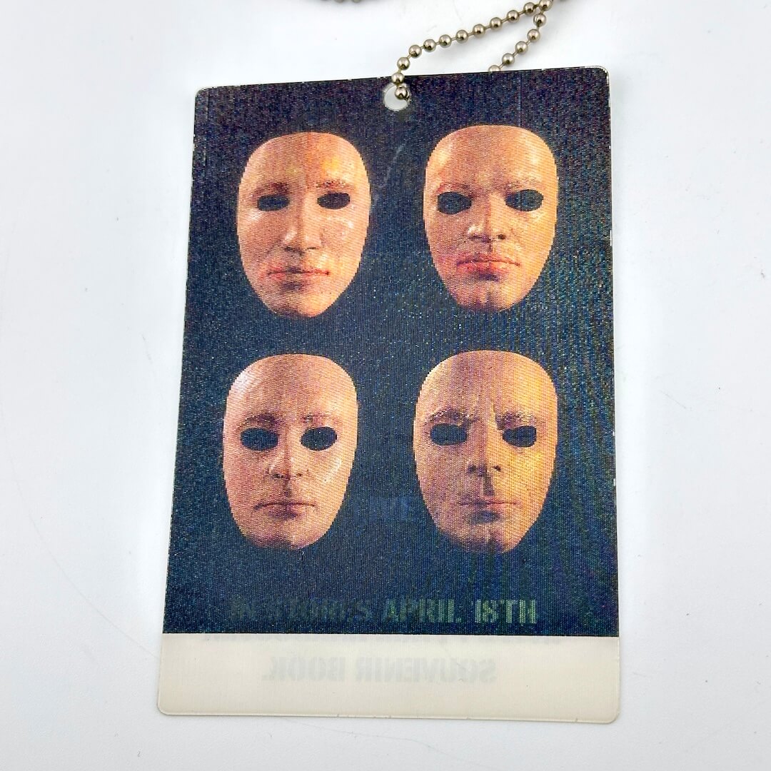 Card with four masks on a dark background, featuring text 'IN STORES APRIL 18TH"
