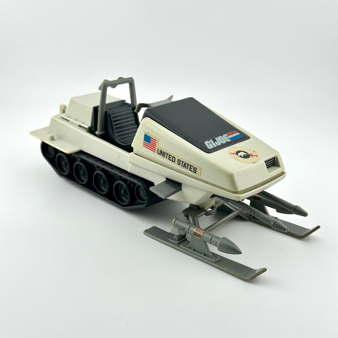 Toy snowmobile with 'United States' and 'G.I. Joe' branding on a white background