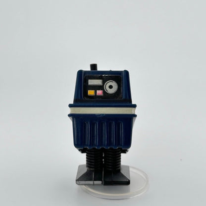 Image of blue box-shaped droid with white stripe around middle, 3 multi-colored buttons on face, black flat feet.