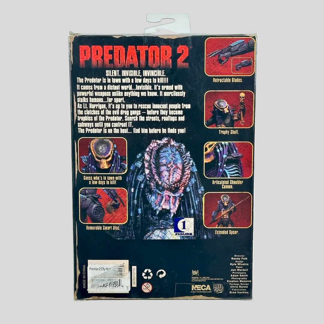 Back of a Predator 2 toy packaging box, showing character art, feature callouts, and NECA branding on a light gray background.