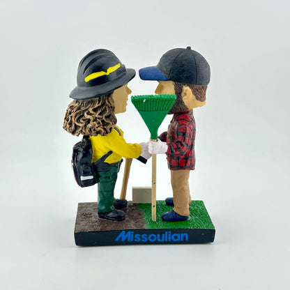 Bobbleheads of a man and woman in outdoor gear with 'Prevent Wildfires' text on a white background