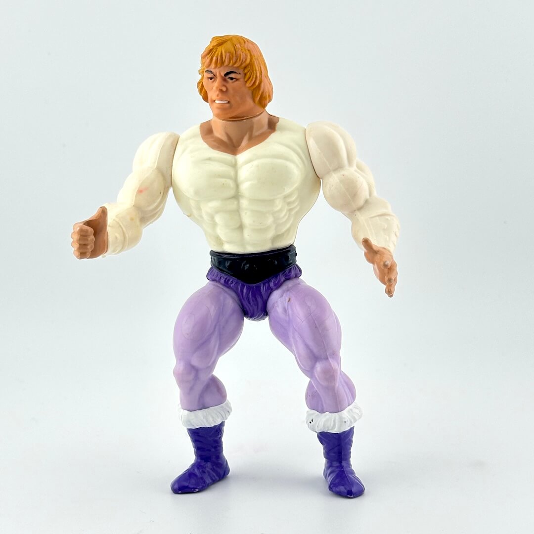 Muscular white male action figure with blonde hair in purple pants and white shirt against white background.
