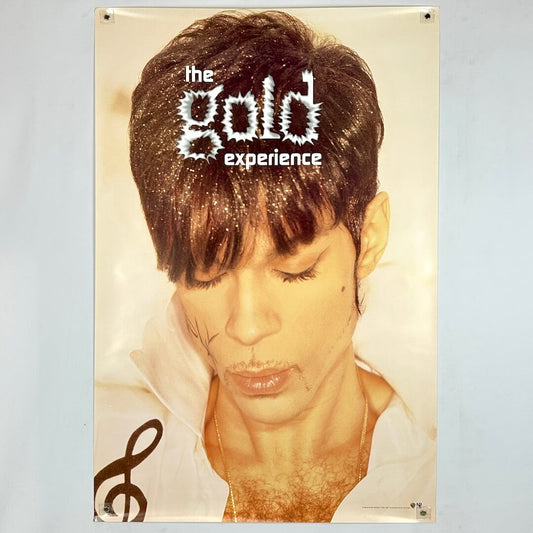 Poster with Prince looking down with  glitter in his hair and gold hue to entire poster. 