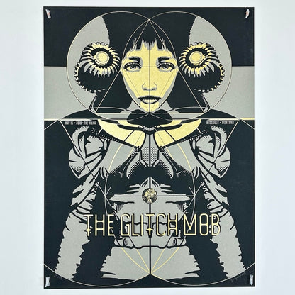 Black poster with woman with gold face wearing gray clothes. Band, venue, and date in gold writing.