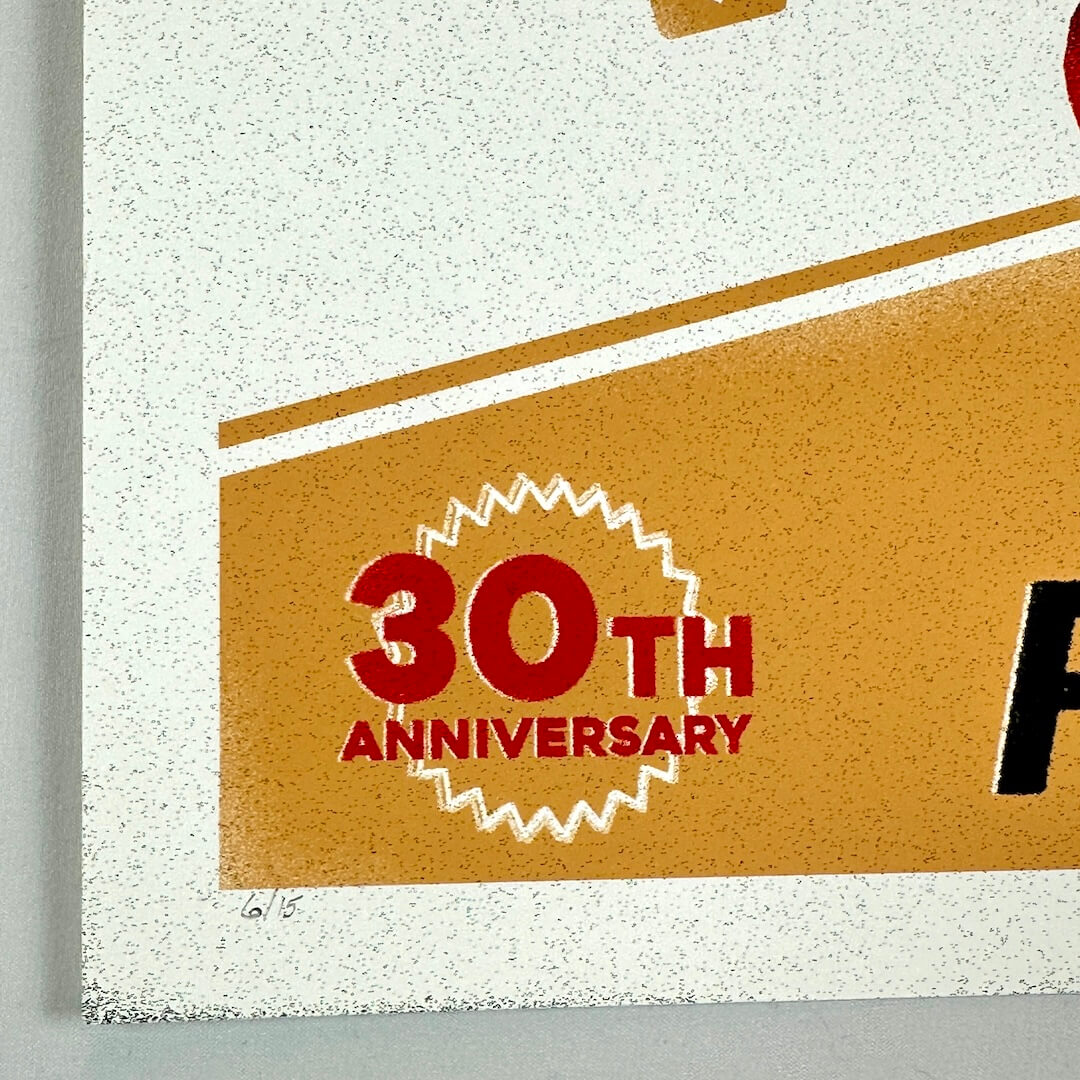 Lower left corner of print with sharp corner and undamaged edges, featuring 30th anniversary seal and print number.