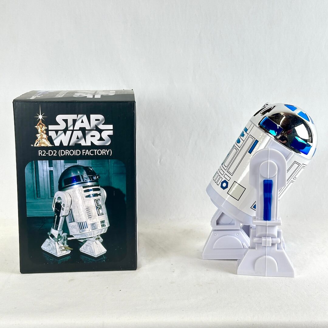 Star Wars R2-D2 (Droid Factory) collectible figure standing next to its original black packaging box.