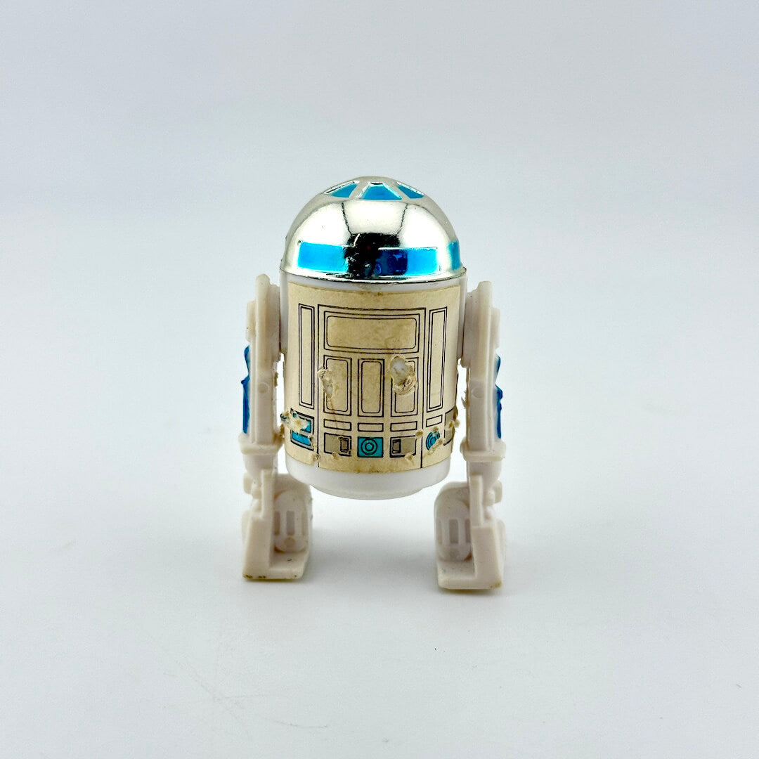 A small droid-shaped figure with a metallic silver dome, blue accents, and a cream-colored body.