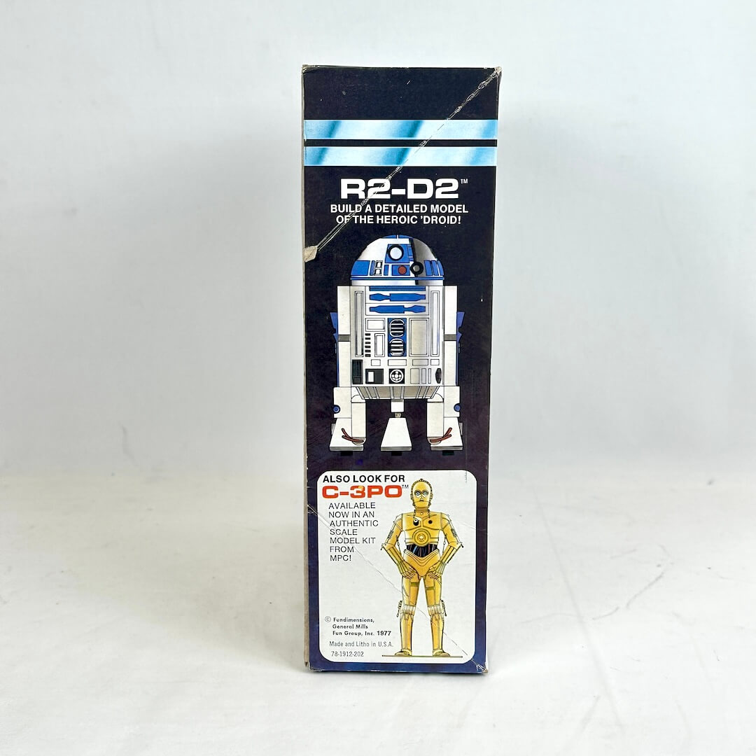 Vintage R2-D2 toy packaging from Star Wars on a white background