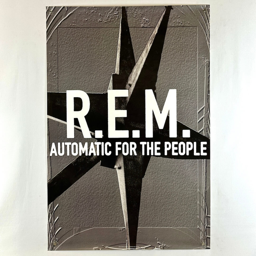 Poster for REM album "Automatic for the People" with gray background and gray spiked thing as center graphic behind text