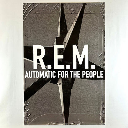 Poster for REM album "Automatic for the People" with gray background and gray spiked thing as center graphic behind text