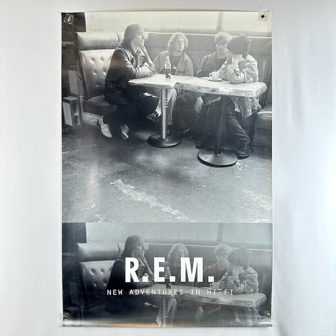 Black and white poster of R.E.M. sitting in a diner with album title 'New Adventures in Hi-Fi'.