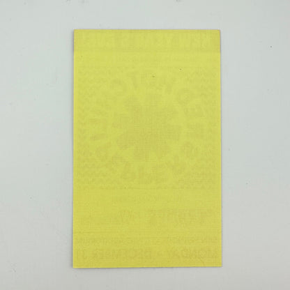 Backside of yellow event ticket against white background showing no damage to ticket.