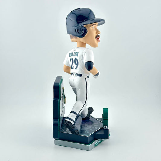 Bobblehead figure of player in white uniform with blue base with Seattle Mariners branding. 
