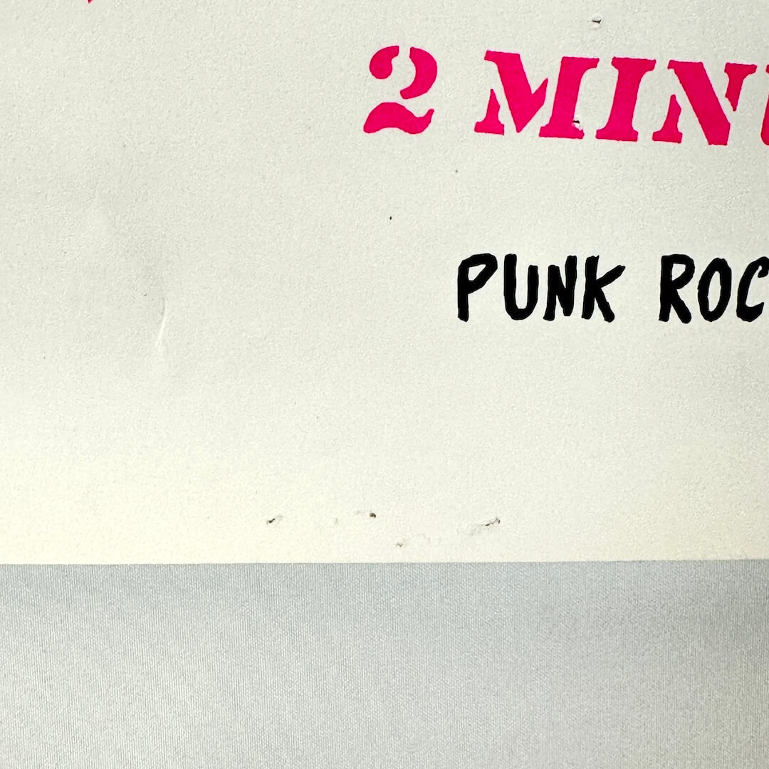 Bottom center of poster with pin/staple holes. 