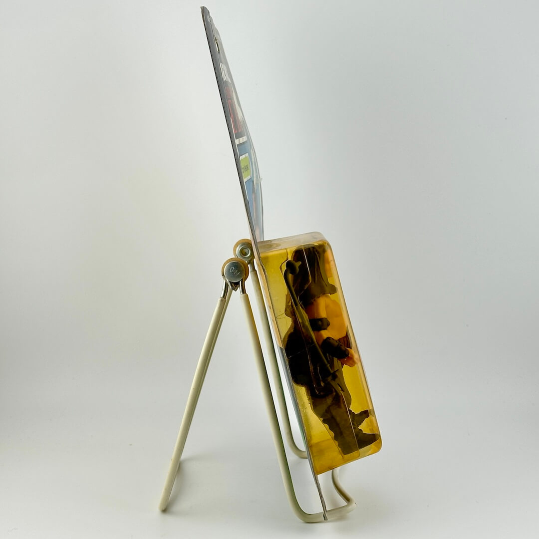 Side view of Star Wars action figure in packaging on easel against white background.