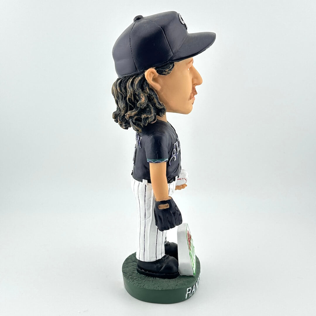 Bobblehead figure of a baseball player in a black uniform with a cap on a white background