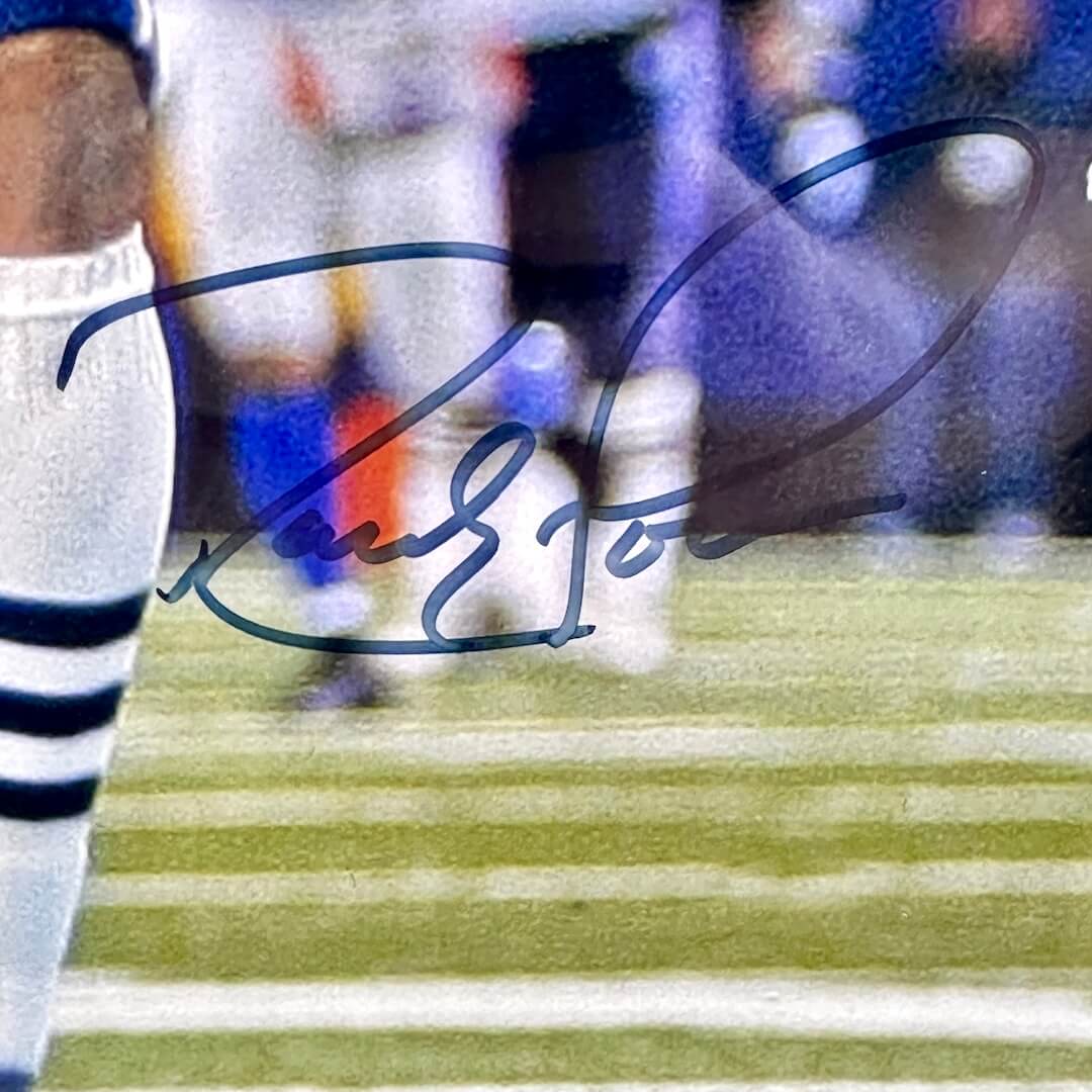 Close-up of black marker signature on photo by player's knee. 
