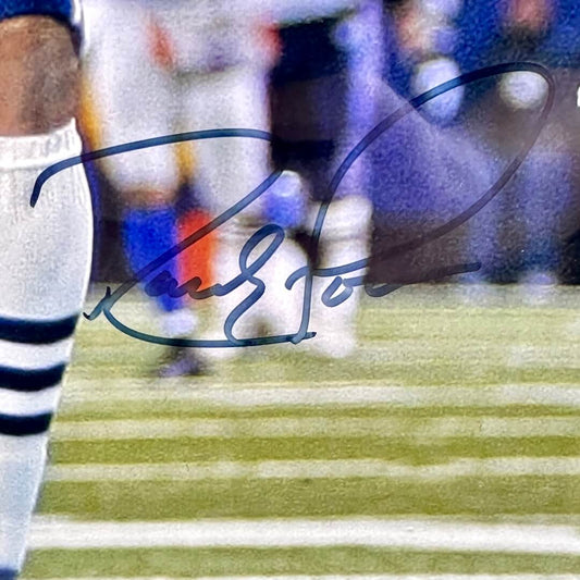 Close-up of black marker signature on photo by player's knee. 