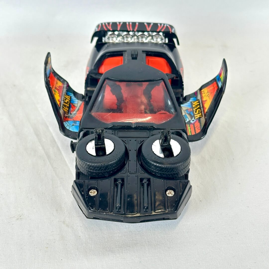 View from the front of a black toy vehicle with orange interior and wing stickers. 