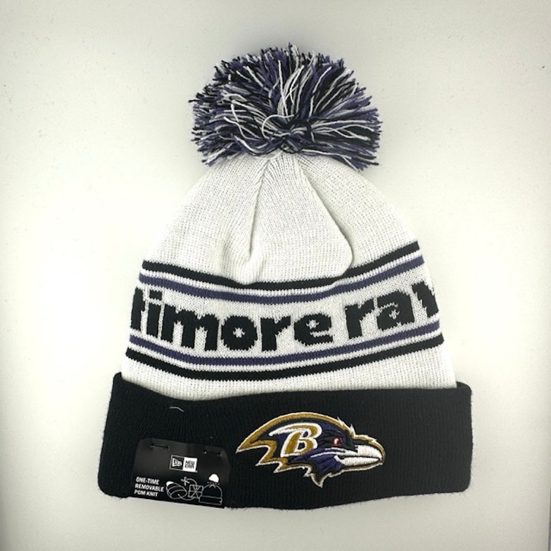 White knit cap with black/purple stripes around black text, black cuff with Ravens logo front center & black/white/purple pom