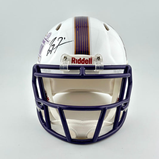 White football helmet with purple face mask and Riddell logo on a gray background