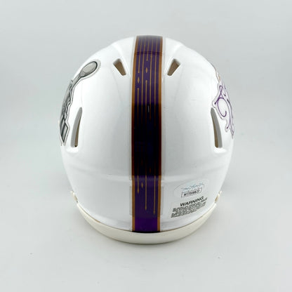 Backside of white mini helmet with purple stripe down center on light gray background. 
