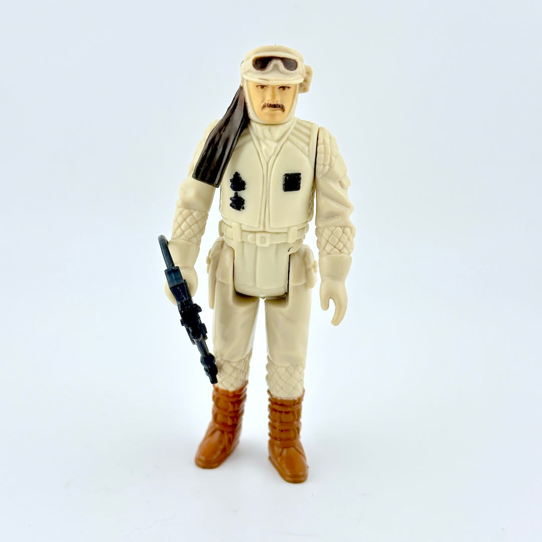 Action figure in desert gear with a rifle on a white background