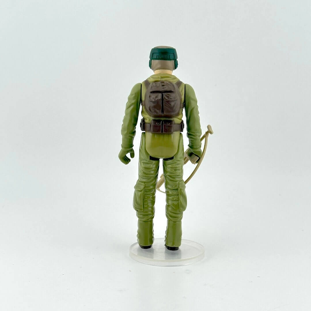 Action figure in green costume with backpack and rifle on a white background