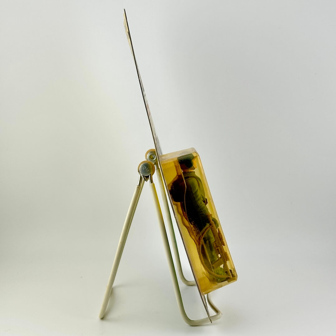 Side view of Star Wars action figure in packaging on easel against white background.