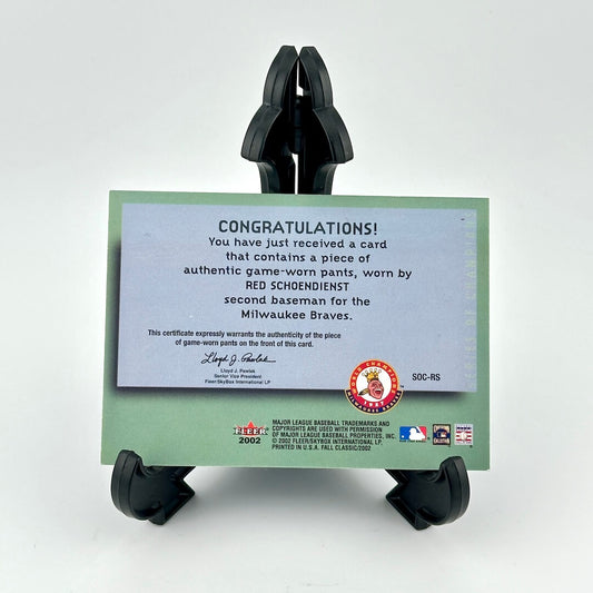Certificate of authenticity for game-worn pants from Red Schoendienst on a stand with a white background