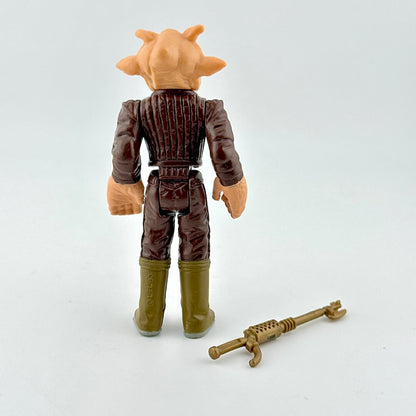 Action figure with brown outfit and helmet, standing next to a weapon on a white background
