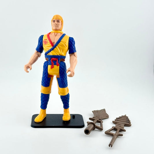 Action figure in blue and yellow outfit with two accessories against white background. 