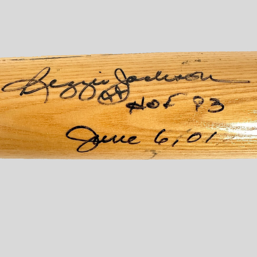 Wooden bat with signatures and text on a white background