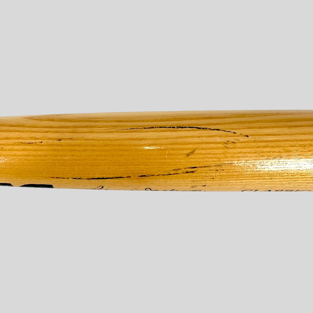Close-up of a wooden bat with visible grain and markings on a white background