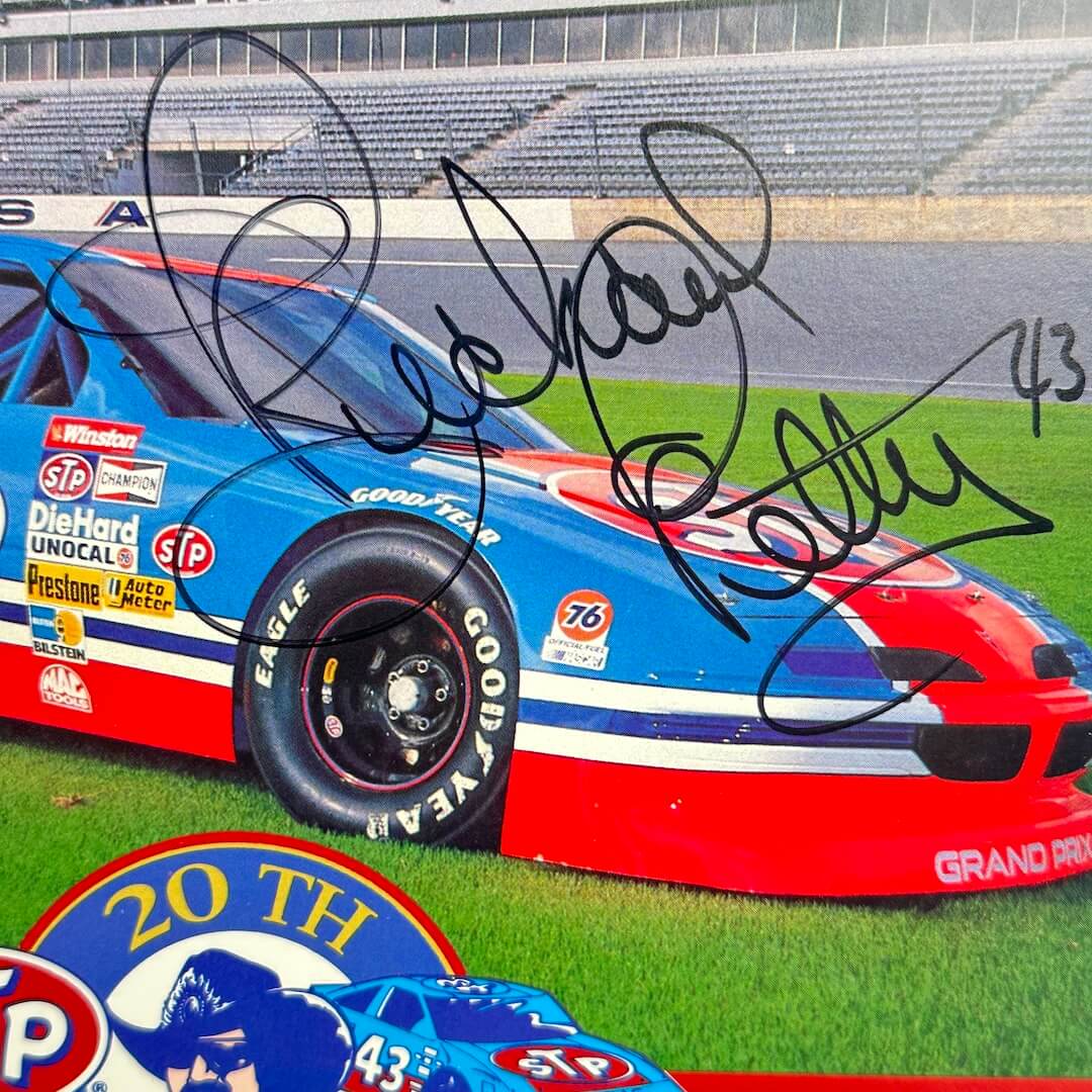 Close-up of black marker signature over hood of car, inscribed "43" next to name. 